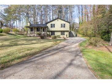 Charming two-story home with a long driveway and well-manicured lawn, nestled among mature trees at 1767 Wingard Dr, Marietta, GA 30062