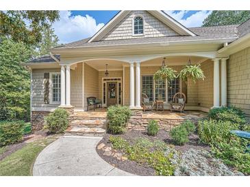 Inviting front porch with stone details and comfortable seating, perfect for relaxing outdoors at 3270 New University Trl, Cumming, GA 30041