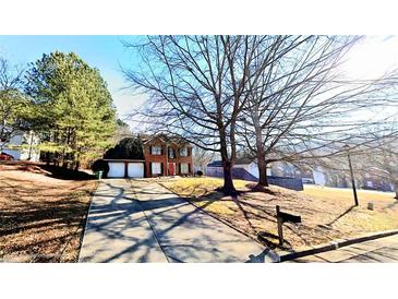 Charming two-story brick home with a well-manicured lawn and a driveway leading to a two-car garage at 3897 Vine Stone Dr, Stonecrest, GA 30038