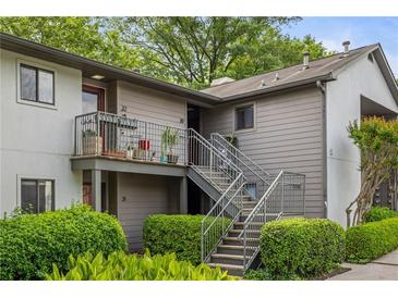 A lovely condo with a charming gray exterior, complete with a balcony, metal stairs, and lush landscaping at 30 Finch Ne Trl, Atlanta, GA 30308