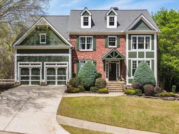 Charming two-story home with a brick facade, green trim, dormer windows, and a well-manicured front yard at 102 Stargaze Rdg, Canton, GA 30114