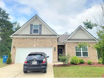 Charming brick home featuring a two-car garage, well-kept lawn, and inviting curb appeal at 1125 Campbell Pine Trl, Lawrenceville, GA 30045