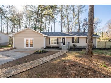 Charming single story home featuring light siding, black shutters, and a welcoming stone walkway and landscaped front yard at 2014 Poplar Rdg, Lawrenceville, GA 30044