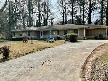 Ranch-style home with long driveway, front porch, and lawn with mature trees offering shade at 4569 Cedar Park Dr, Stone Mountain, GA 30083