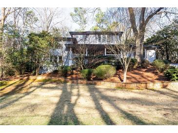 Charming two-story home with stone retaining wall and mature trees at 2740 Margaret Mitchell Nw Dr, Atlanta, GA 30327