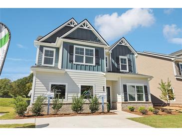 Charming two-story home with a mix of blue and white siding, complemented by well-maintained landscaping at 11837 Rizvan Pl, Covington, GA 30014