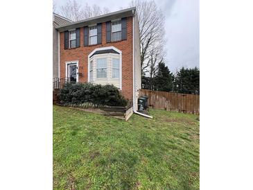 Charming brick townhome featuring a bay window and well-maintained front yard at 1672 Cedar Bluff Way, Marietta, GA 30062