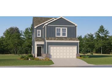 Charming two-story home featuring blue siding, a two-car garage, and a well-manicured front lawn at 2452 Cotton Ln, Douglasville, GA 30135