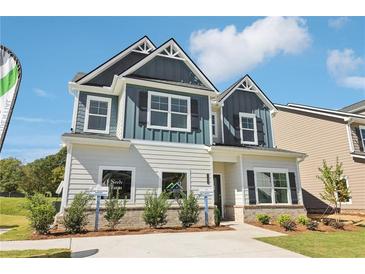 Charming two-story home with blue and white siding, a well-manicured lawn, and a welcoming entrance at 11102 Suria Dr, Covington, GA 30014