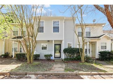Charming two-story townhome with a welcoming front porch and mature landscaping creating an inviting curb appeal at 2376 Wellington Cir, Lithonia, GA 30058