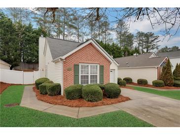 Charming brick home with lush landscaping and a well-maintained lawn, perfect for curb appeal at 1029 Daventry Xing, Woodstock, GA 30188