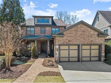 Charming brick home with a two-car garage, landscaped front yard, and inviting entryway at 3405 Camellia Ln, Suwanee, GA 30024