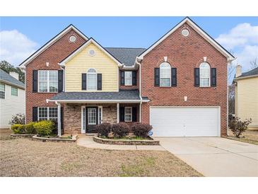 Traditional two-story home with brick and siding, black shutters, and an attached two-car garage at 907 Hindman Pl, Mcdonough, GA 30253