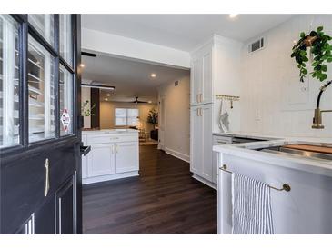 Modern kitchen features white cabinets, quartz countertops, stainless steel sink and view into the home's open floor plan at 4282 Roswell Ne Rd # G1, Atlanta, GA 30342