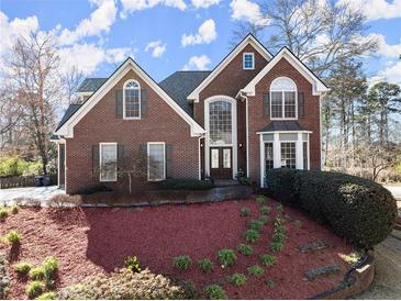 Charming two-story brick home with manicured front yard and arched windows at 1897 De Winton Pl, Lawrenceville, GA 30043