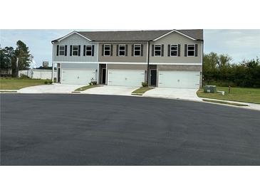 New townhomes featuring attached garages, neutral colors and nicely landscaped front yards at 8666 Webb Rd, Riverdale, GA 30274