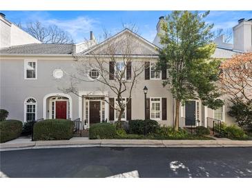Exterior view of townhome with gray facade, well-maintained landscaping, and a red front door at 111 Paces Run, Atlanta, GA 30339