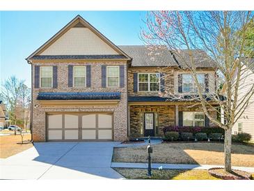 Charming two-story home featuring a brick and stone facade, attached two-car garage, and manicured lawn at 3129 Arbor Oaks Dr, Snellville, GA 30039
