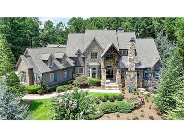 Stately stone and shingle home with manicured landscaping and charming blue shutters at 829 Big Horn Holw, Suwanee, GA 30024