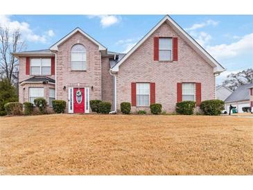 Two-story brick home with a red front door, shutters, and a well-manicured lawn at 1644 Cutters Mill Dr, Lithonia, GA 30058