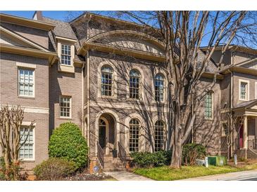 Elegant brick home with arched windows and a well-maintained front yard, showing classic architectural details at 2009 Kensington Green Se Dr, Smyrna, GA 30080