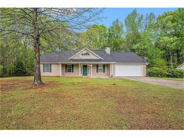 Charming single-story home with a well-maintained lawn and attached two-car garage at 60 Cypress Dr, Covington, GA 30016