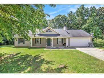 Charming single-story home featuring a well-manicured lawn, inviting front porch, and attached two-car garage at 60 Cypress Dr, Covington, GA 30016