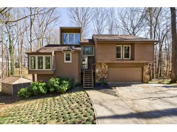 Unique split-level home boasts lots of windows, mature trees, a two-car garage, and attractive landscaping at 2664 Stonebrook Ne Ct, Roswell, GA 30075