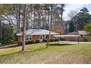 Charming single-story brick home with a well-maintained lawn and convenient carport at 2251 Trailwood Se Dr, Smyrna, GA 30080