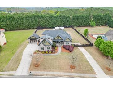Beautiful home with well-manicured lawn, mature trees, and a spacious driveway, offers classic suburban charm at 1698 Little Fox Ln, Dacula, GA 30019