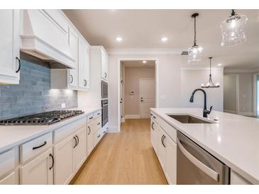 Bright kitchen boasts white cabinets, stainless appliances, and quartz counters, perfect for modern living at 108 Redford Ln, Canton, GA 30115