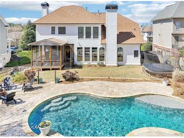 Gorgeous backyard with a refreshing in-ground pool, screened in porch and manicured lawn, perfect for entertaining at 3530 Horizon Ct, Cumming, GA 30041