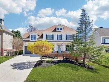 Charming two-story home with a well-manicured lawn, colorful tree and inviting front porch at 3530 Horizon Ct, Cumming, GA 30041