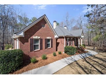 Charming one-story brick home with manicured landscaping and inviting walkway at 9246 W Banks Mill Rd, Winston, GA 30187