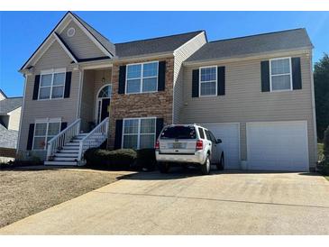 Charming two-story home with stone accents, a well-manicured lawn, and attached two-car garage at 252 Berkley Dr, Villa Rica, GA 30180