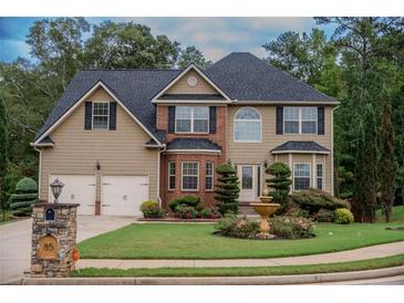 Charming two-story home boasts a manicured front lawn and well-maintained landscaping with a two car garage at 85 Providence Pkwy, Covington, GA 30014