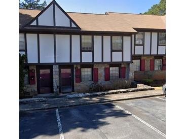 Traditional townhome features stone accents, Tudor-style details, and convenient parking at 1411 Brixton Cir, Stone Mountain, GA 30083