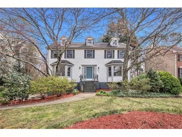 Charming two-story home with dormer windows, a well-manicured lawn and mature trees at 930 Camden Hill Ct, Lawrenceville, GA 30046