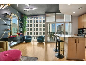 Bright living room with large windows and city views plus stylish decor, including a modern kitchen island at 943 Peachtree Ne St # 1603, Atlanta, GA 30309