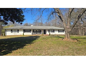 Charming single-story home with a white exterior, black shutters, and a spacious front yard, exuding curb appeal at 187 Bowden Rd, Ellenwood, GA 30294