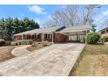 Charming brick home featuring a long driveway and covered carport at 1421 Downs Sw Dr, Atlanta, GA 30311