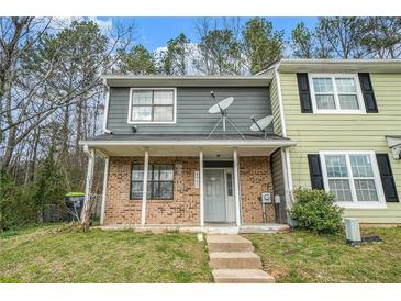 Charming townhome featuring a brick facade, covered porch, and a well-maintained front yard at 6962 Oakhill Cir, Austell, GA 30168