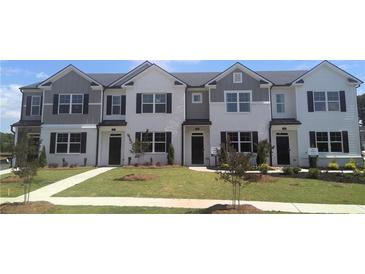 View of new construction townhomes with painted brick and neutral siding, landscaped with grass at 452 Reflection Dr # 19, Stockbridge, GA 30281