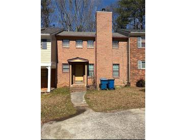 A two-story red brick house with a walkway leading up to a front door at 7123 Williamsburg Dr, Riverdale, GA 30274