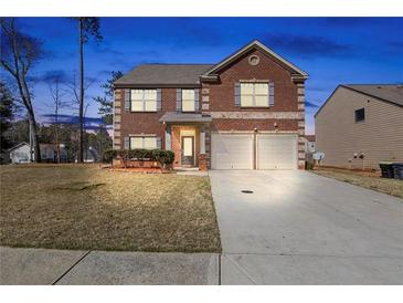 Charming two-story brick home features a two-car garage and well-maintained front lawn at 15 Mary Jane Ln, Covington, GA 30016