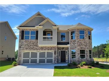 Beautiful two-story home with a brick and gray facade, a two-car garage, and a manicured lawn at 3818 Southfield Ct, Loganville, GA 30052