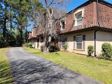 Charming townhomes featuring red roofs and private driveways, surrounded by lush trees at 2992 Parc Lorraine, Lithonia, GA 30038
