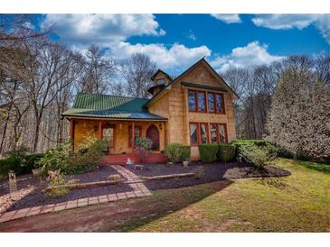 Charming two-story home with a landscaped yard, a green roof, and eye-catching windows at 5642 N Highway 212, Covington, GA 30016