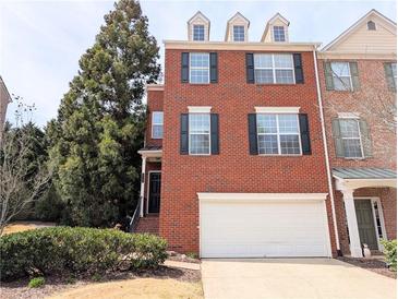 Charming brick townhouse with a one-car garage and well-maintained landscaping at 11780 Wellsley Way, Alpharetta, GA 30005