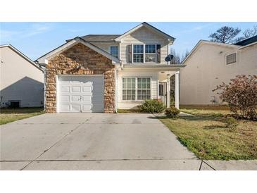Charming two-story home featuring stone accents, attached garage, and well-maintained lawn at 6439 Grey Fox Way, Riverdale, GA 30296